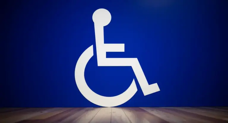 Simbolo della disabilità su sfondo blu con pavimento in legno