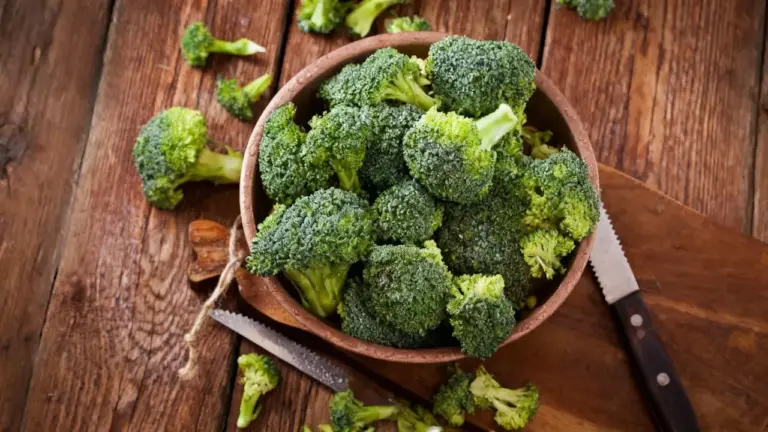 Ciotola di broccoli freschi su un tavolo di legno con coltello accanto