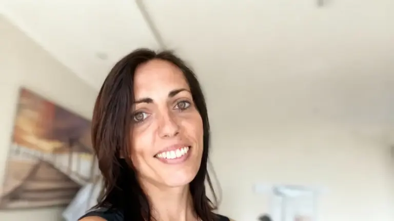 Una persona sorride in un ambiente interno luminoso