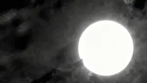 Oggetto luminoso circondato da nubi scure in un cielo notturno