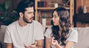 Due persone sedute su un divano mentre discutono animatamente