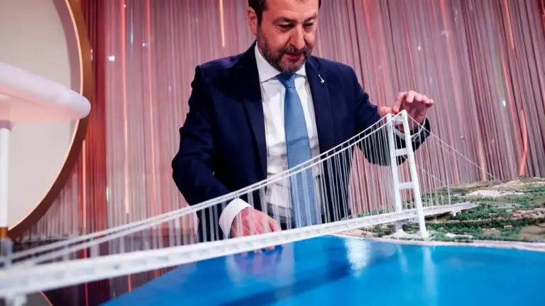 Una persona osserva un plastico del Ponte sullo Stretto di Messina