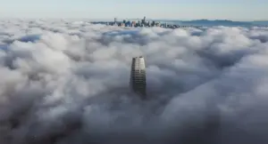 Grattacielo emerge dalla nebbia con skyline urbano sullo sfondo