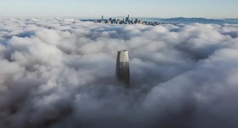 Grattacielo emerge dalla nebbia con skyline urbano sullo sfondo