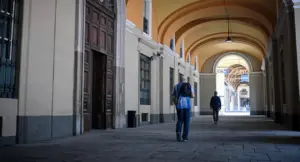 Due persone camminano sotto un portico in una città