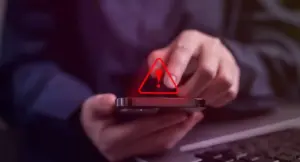 Persona che utilizza uno smartphone con un'icona di avviso sullo schermo