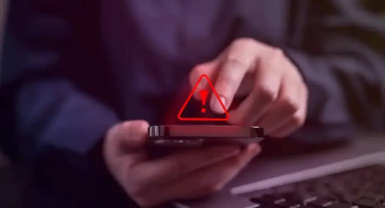 Persona che utilizza uno smartphone con un'icona di avviso sullo schermo