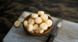 Ciotola di semi chiari su un tagliere con coltello da cucina