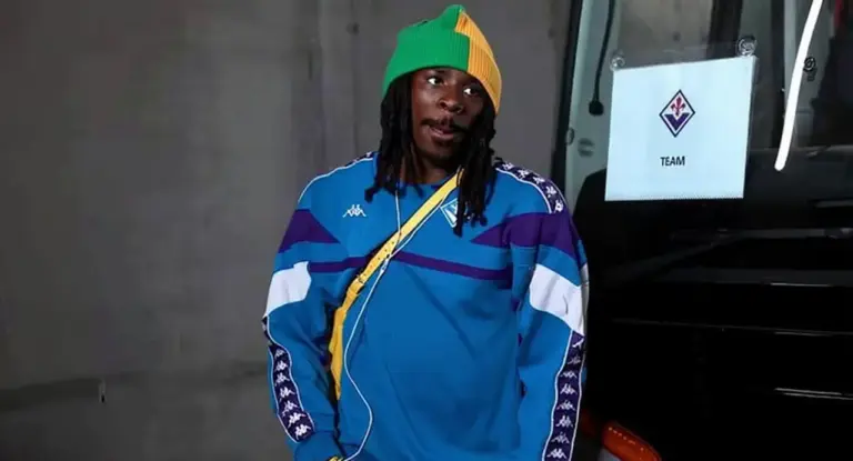 Un giocatore della Fiorentina con tuta ufficiale accanto al pullman della squadra